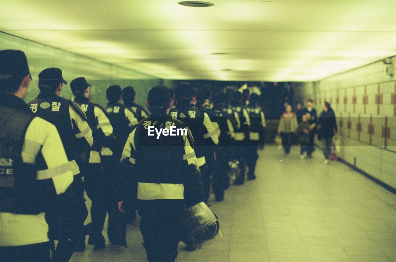 GROUP OF PEOPLE STANDING IN ILLUMINATED UNDERGROUND