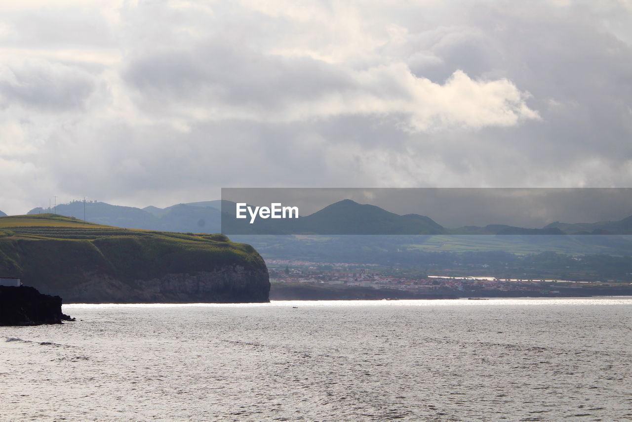 SCENIC VIEW OF SEA AGAINST MOUNTAINS