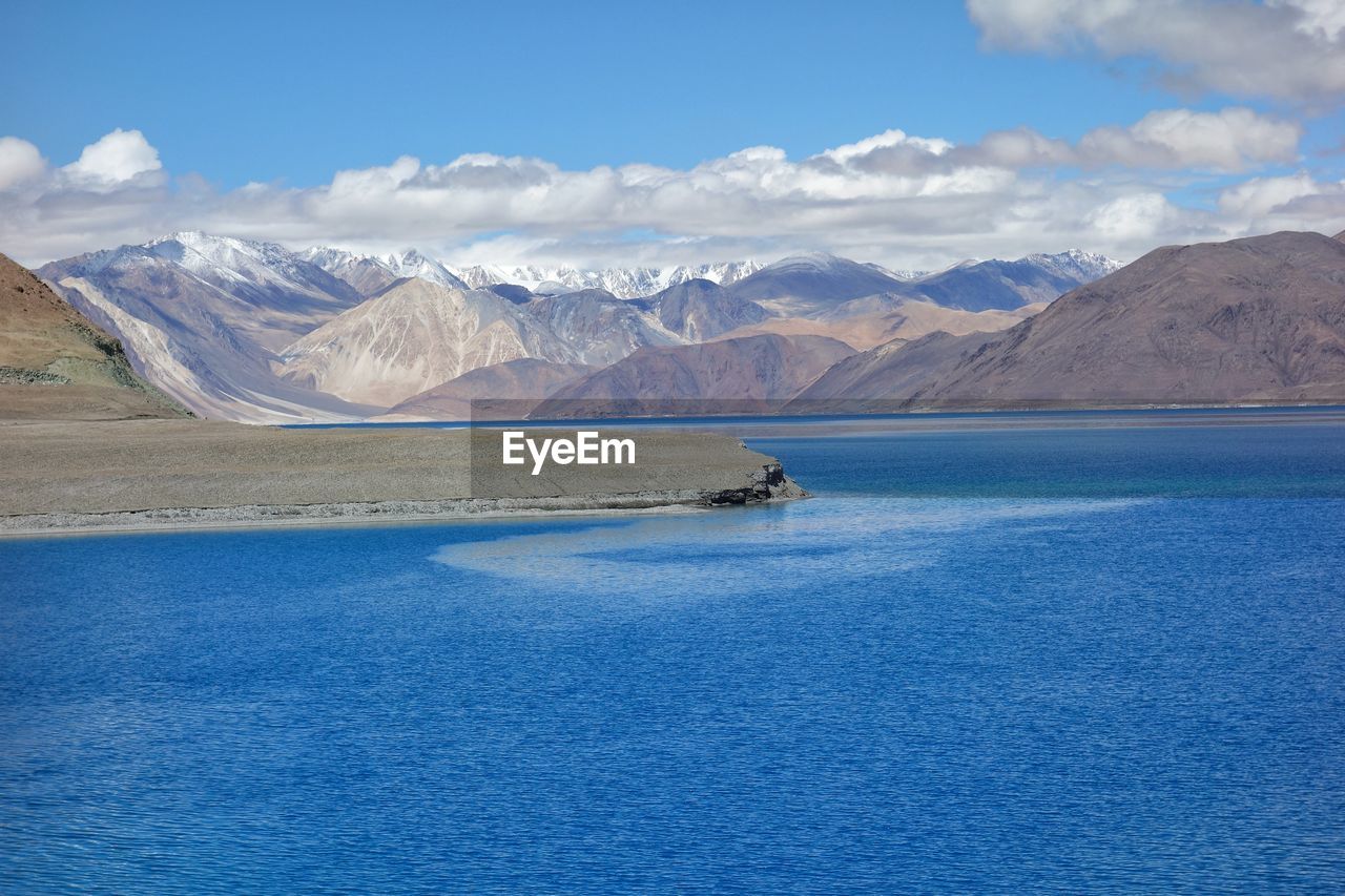 Scenic view of sea and mountains against sky