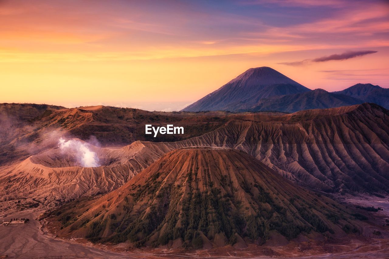 Panoramic view of volcanic crater against sky during sunset