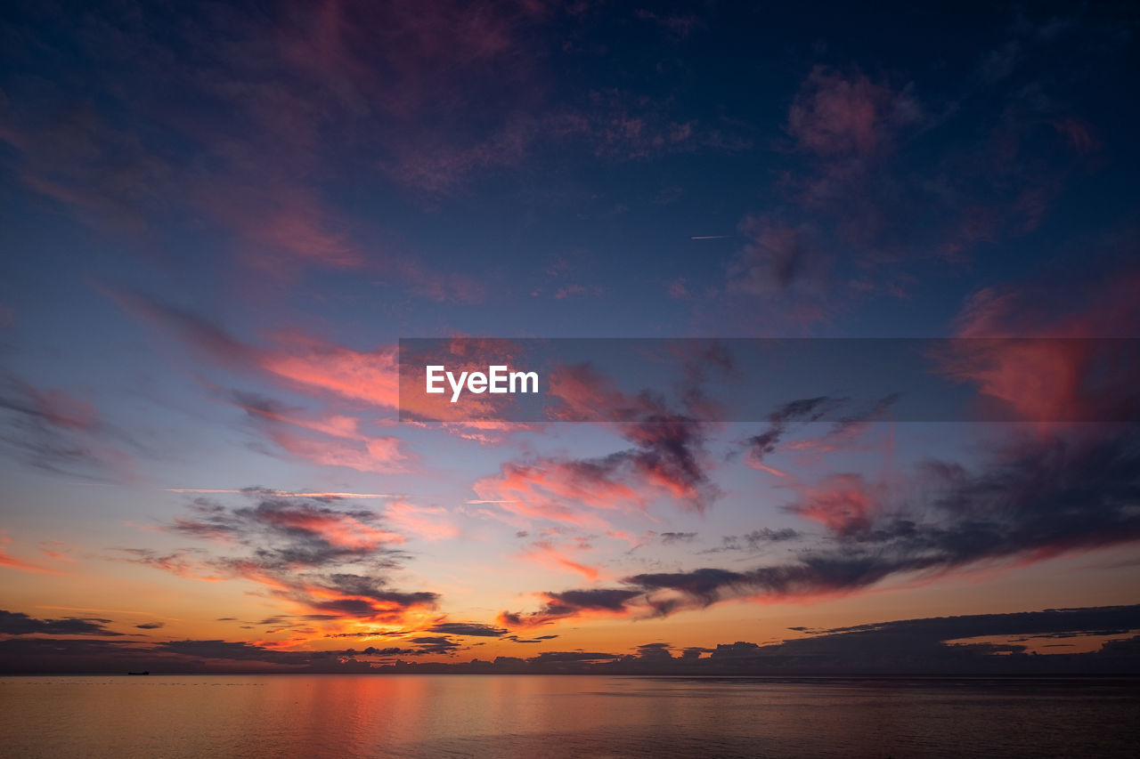 Scenic view of sea against romantic sky at sunset