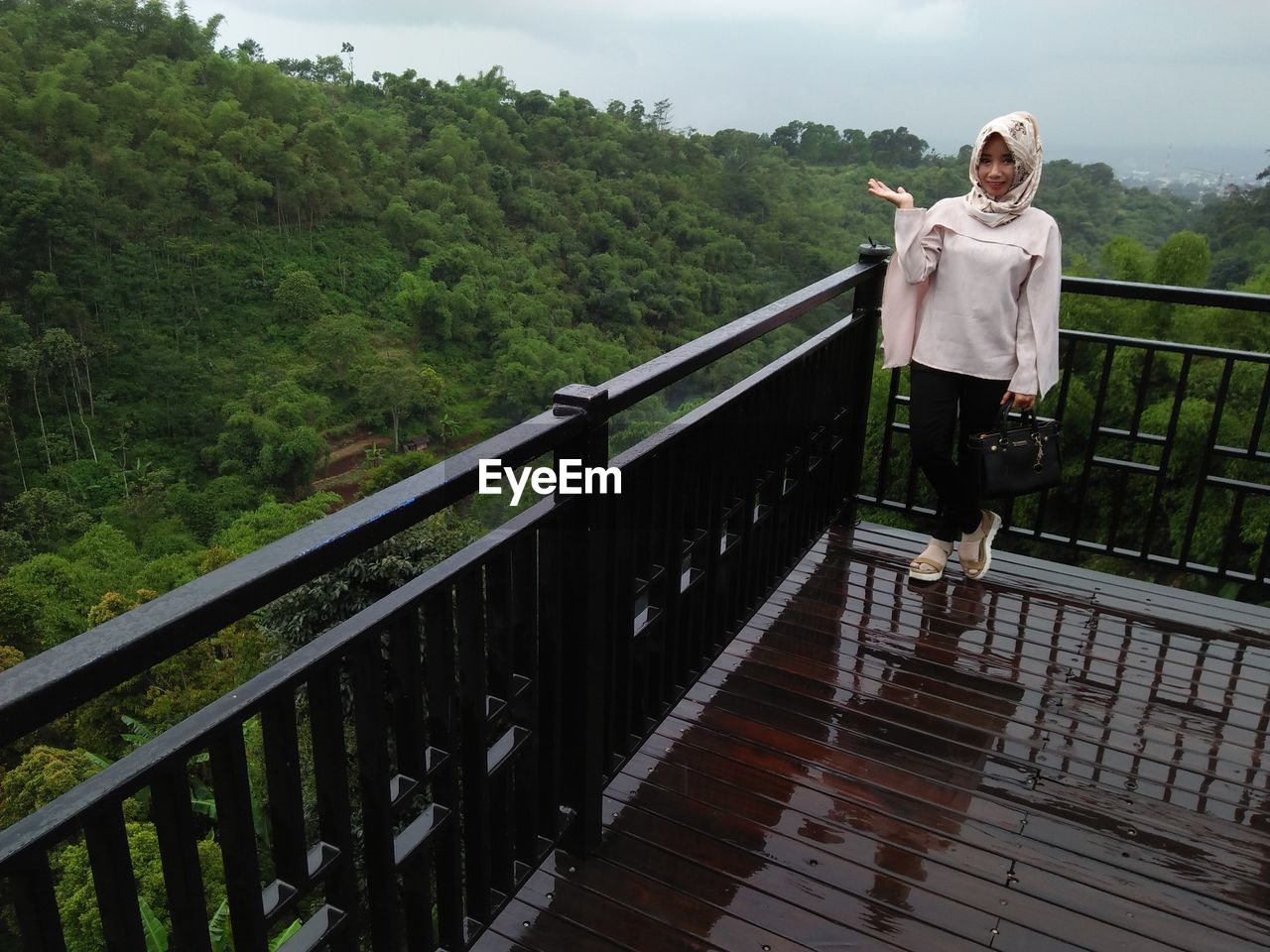 Portrait of smiling woman in hijab standing at observation point