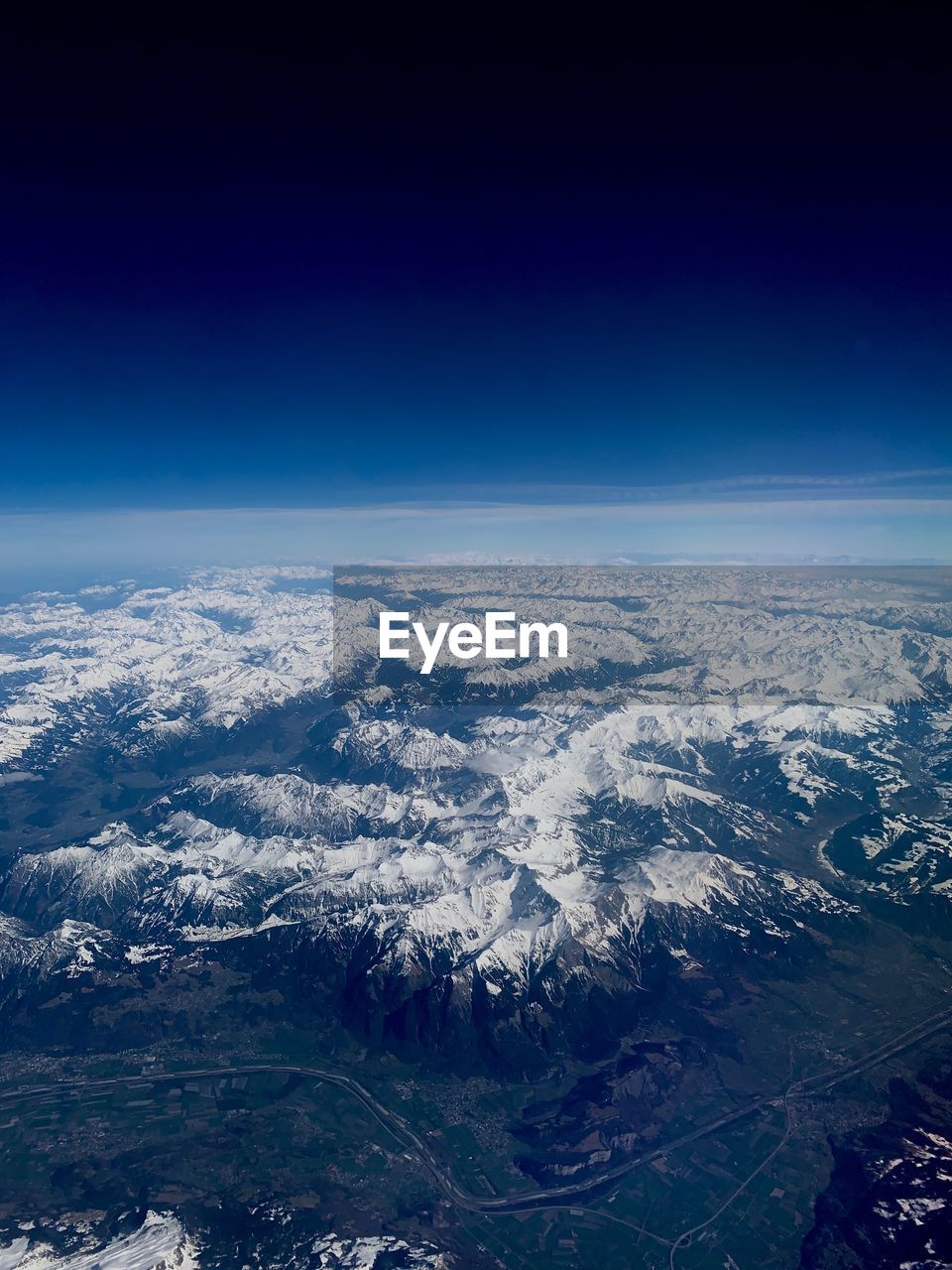 AERIAL VIEW OF SNOWCAPPED MOUNTAINS AGAINST SKY