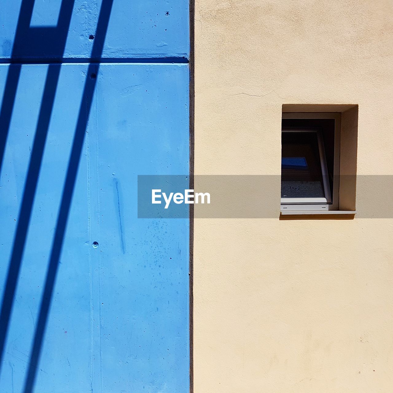 LOW ANGLE VIEW OF BLUE WINDOW ON WALL