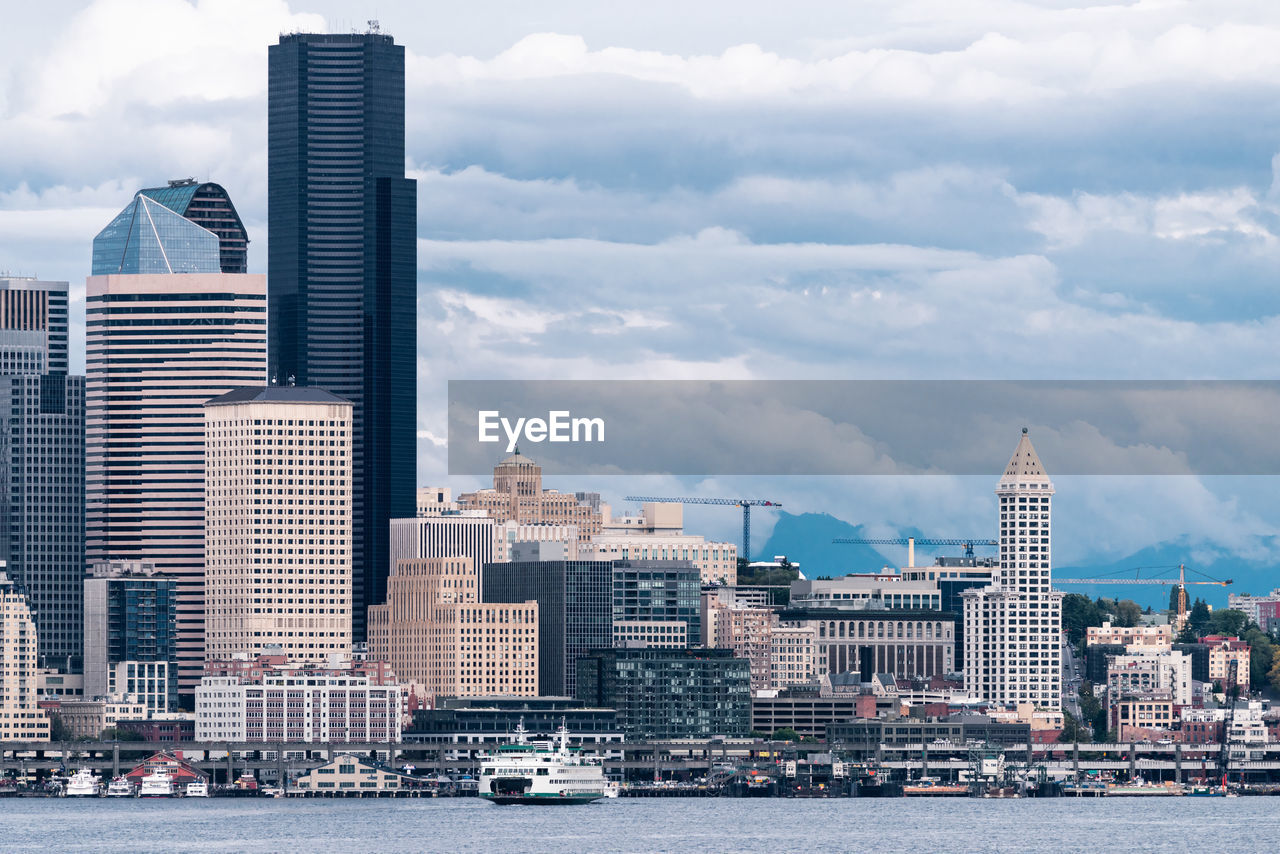 Buildings in city against cloudy sky