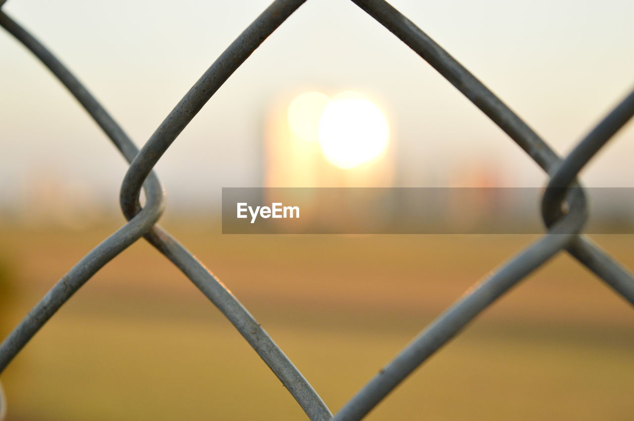 Close-up of chainlink fence against sky