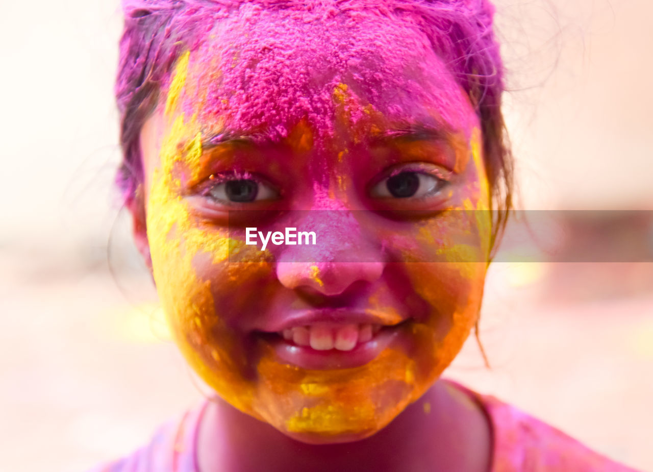 Close-up portrait of girl with holi colors on face