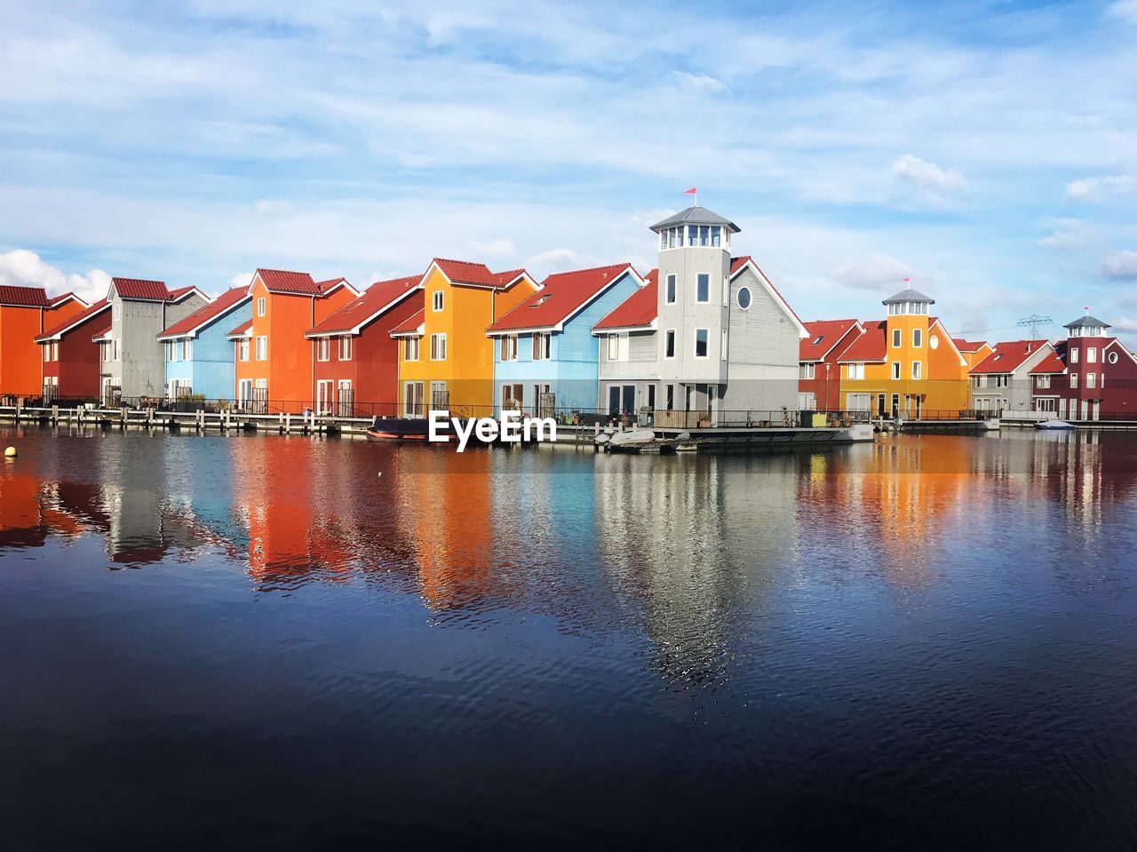 Reflection of buildings in sea against sky