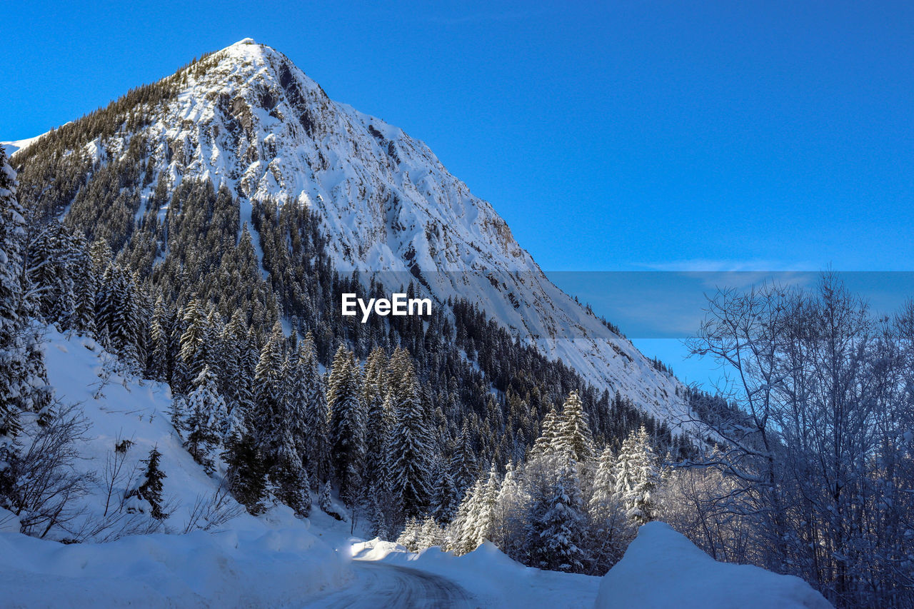 SNOW COVERED MOUNTAINS AGAINST SKY