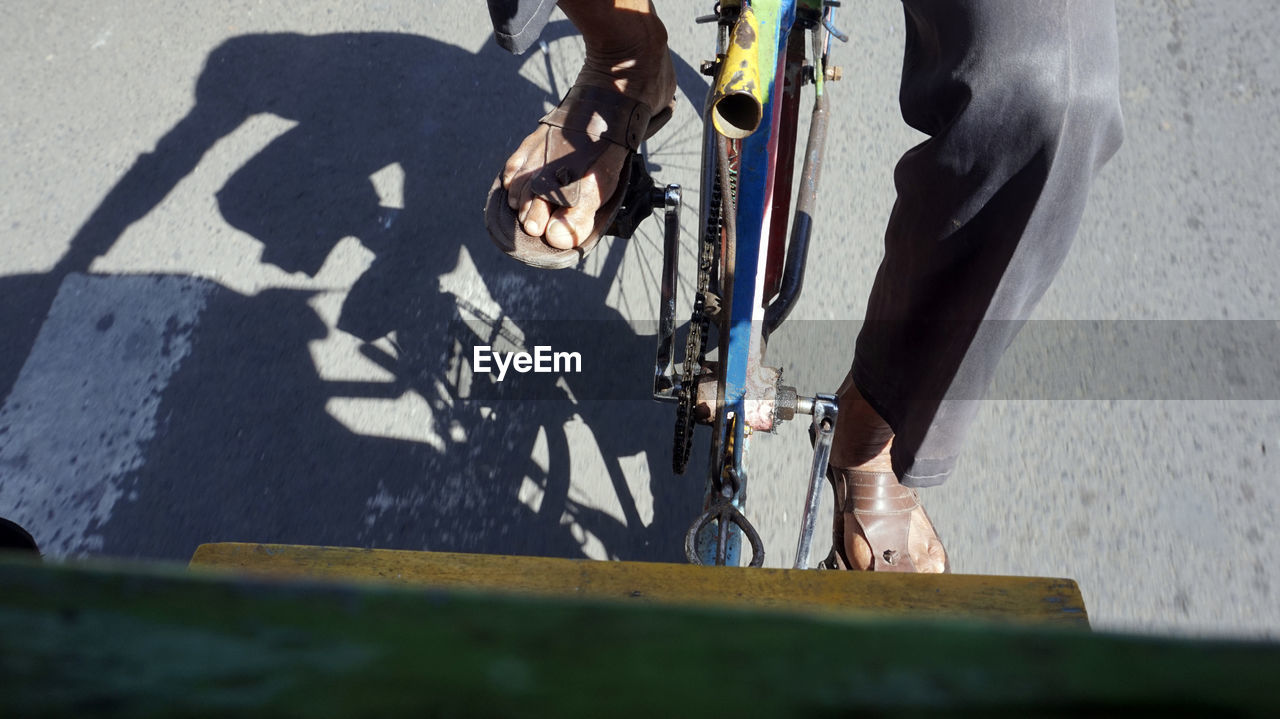 Low section of man riding bicycle on street