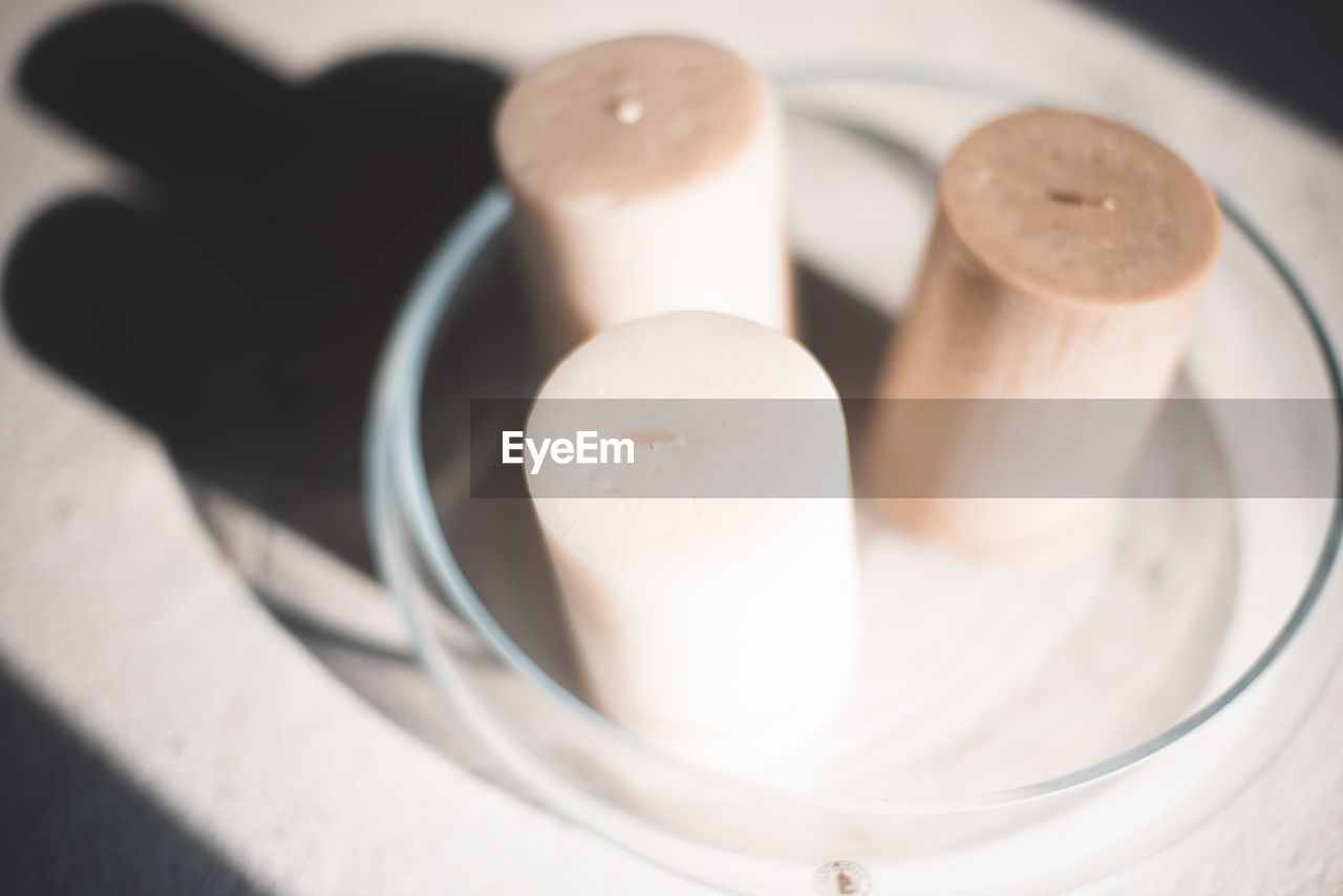 HIGH ANGLE VIEW OF EGG IN CONTAINER ON TABLE