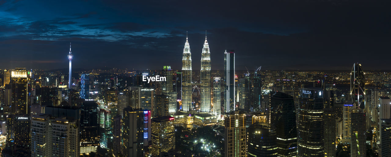 Illuminated cityscape against sky at night