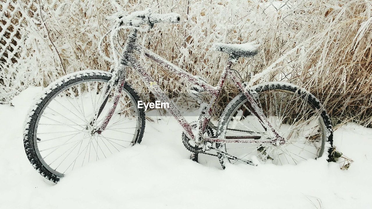 CLOSE-UP OF BICYCLE PARKED ON SNOW