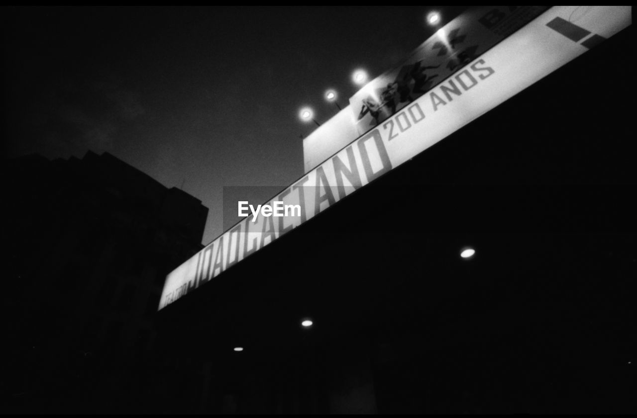 LOW ANGLE VIEW OF ILLUMINATED BUILDING AT NIGHT