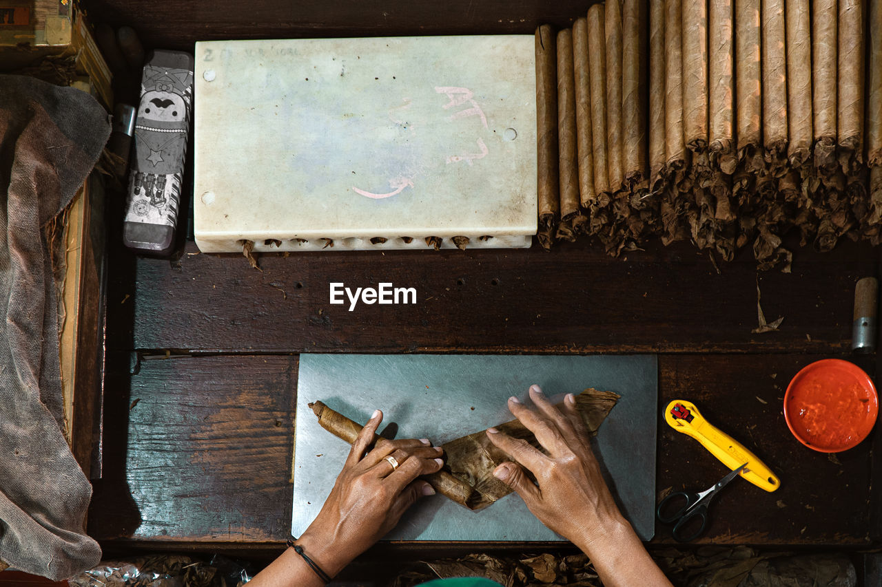 Top view of cigar maker hand rolling. manual cigar spinning rolling process at a cigar factory