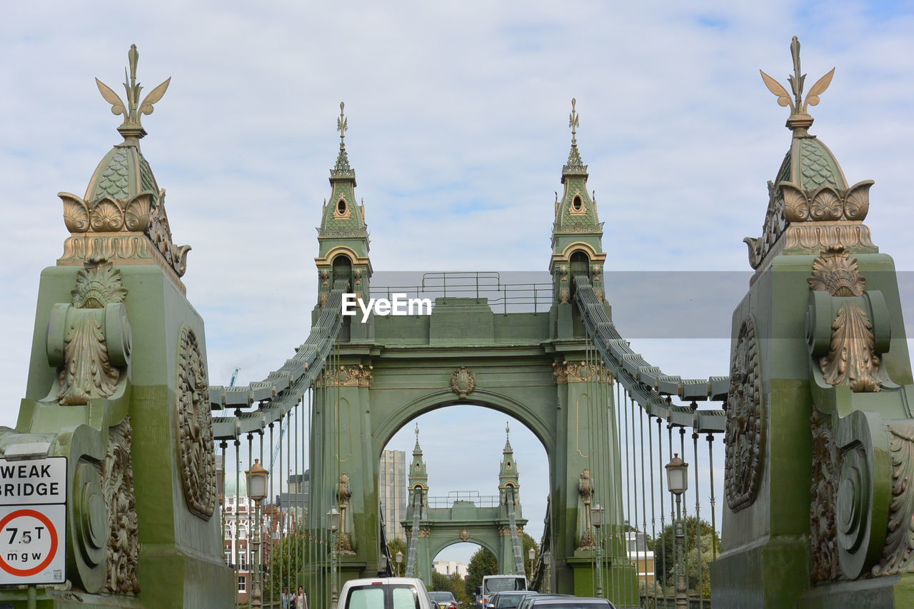 Cars moving on hammersmith bridge against cloudy sky