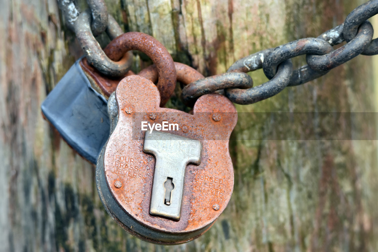 Close-up of rusty metallic locks attached to chain