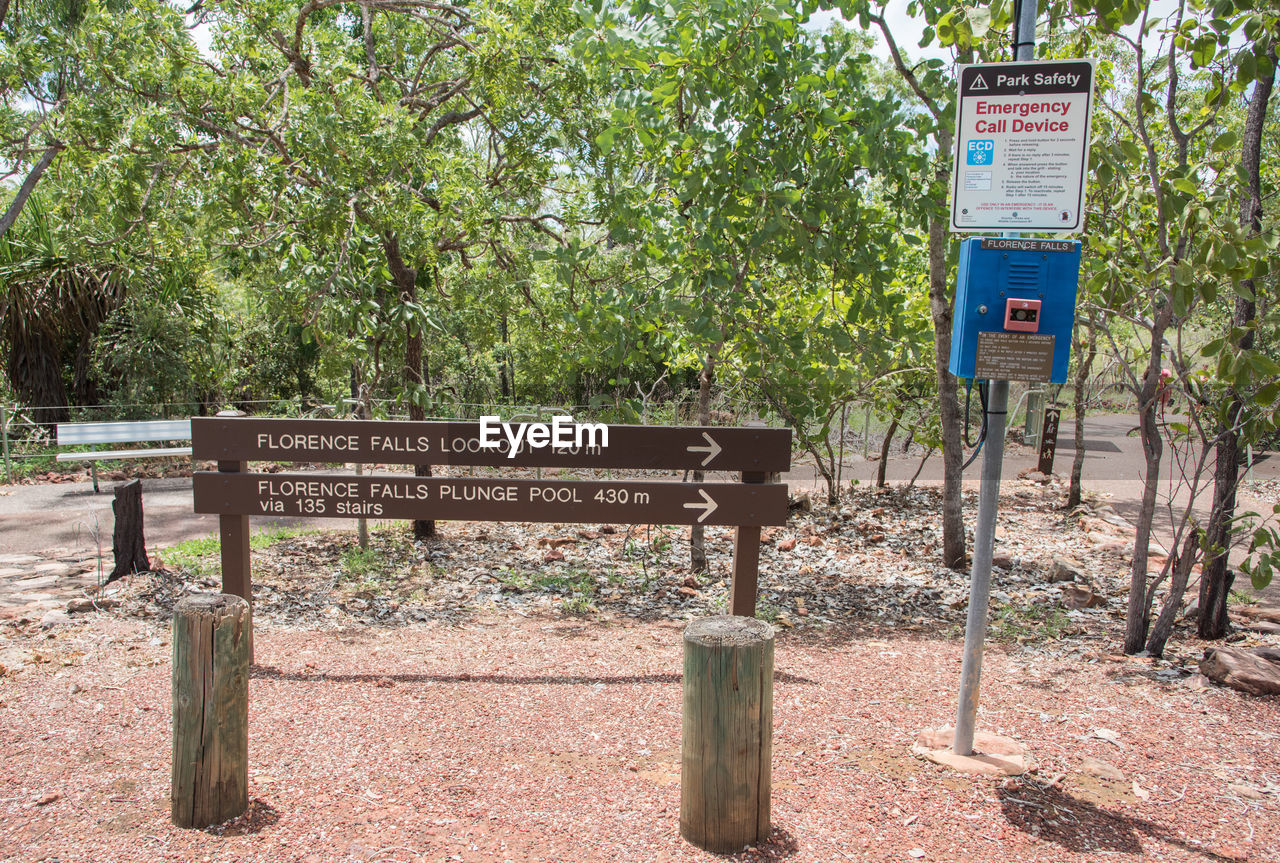 INFORMATION SIGN ON ROAD BY TREES