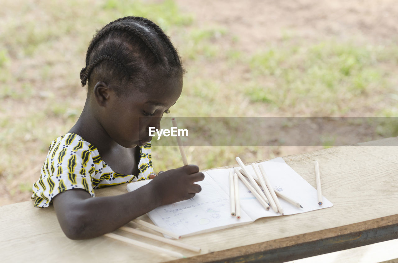 Close-up of girl writing in book