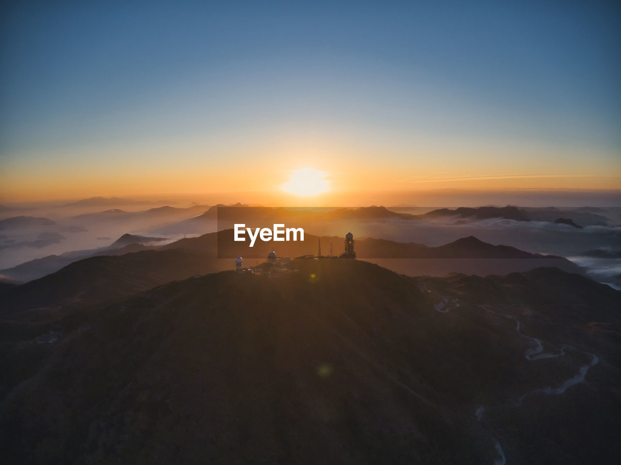 Silhouette people on mountain against sky during sunset