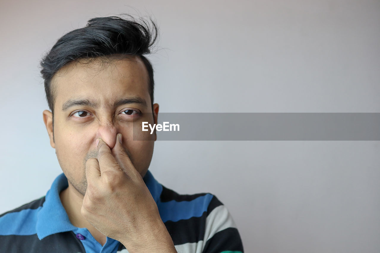 PORTRAIT OF MAN AGAINST WHITE BACKGROUND