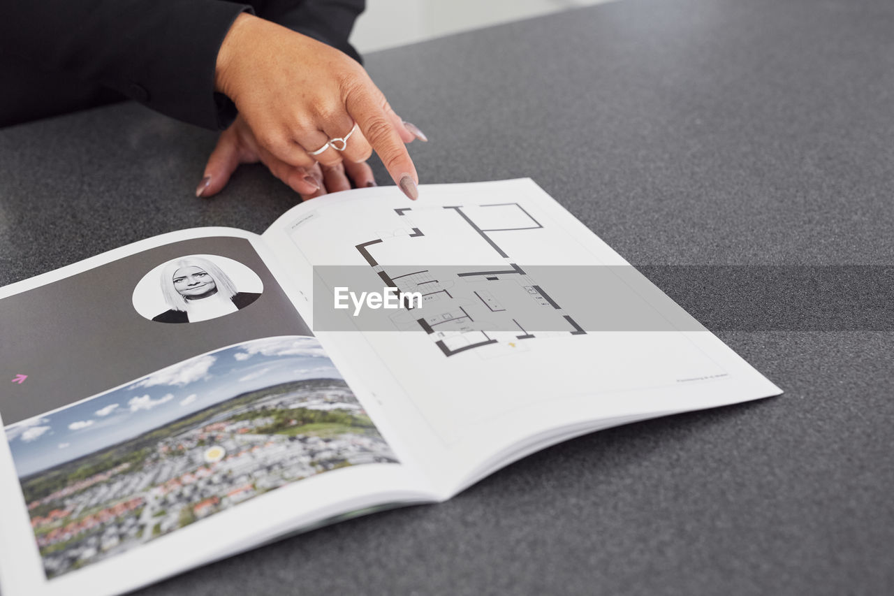 Female estate agent showing house brochure