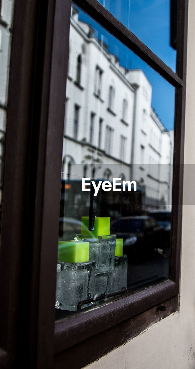 REFLECTION OF BUILDINGS ON GLASS WINDOW