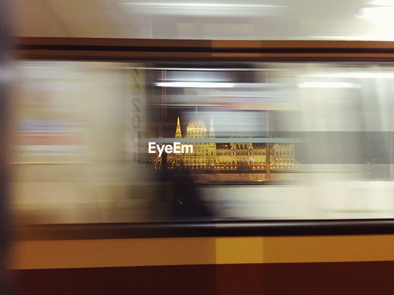 Blurred motion of subway train against illuminated hungarian parliament building