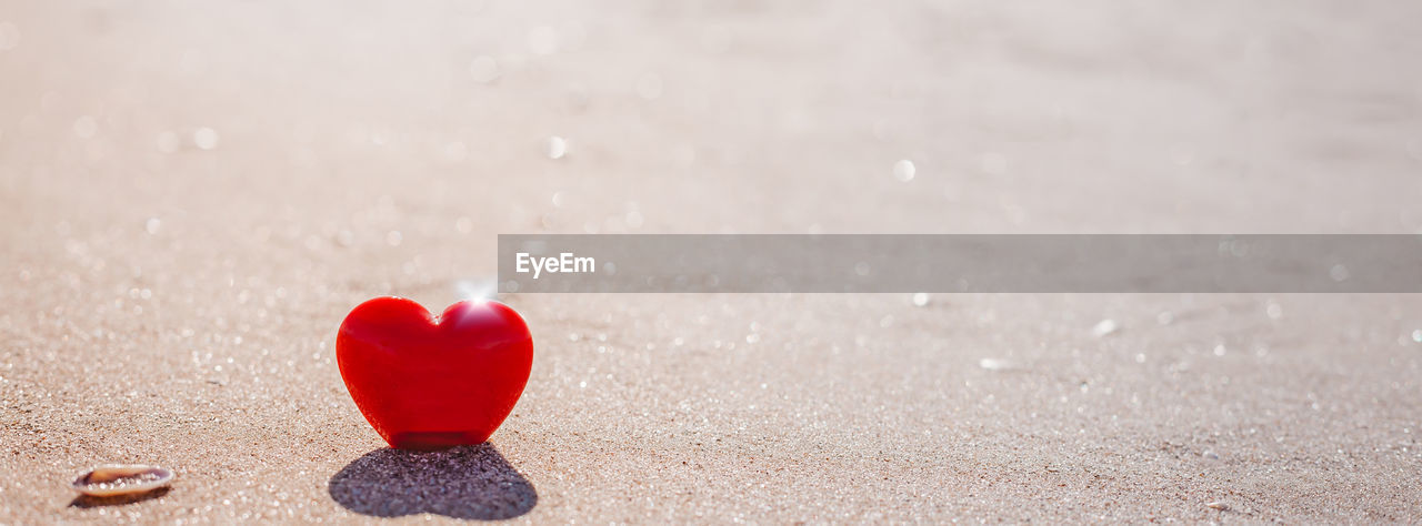 CLOSE-UP OF RED TOY ON SAND