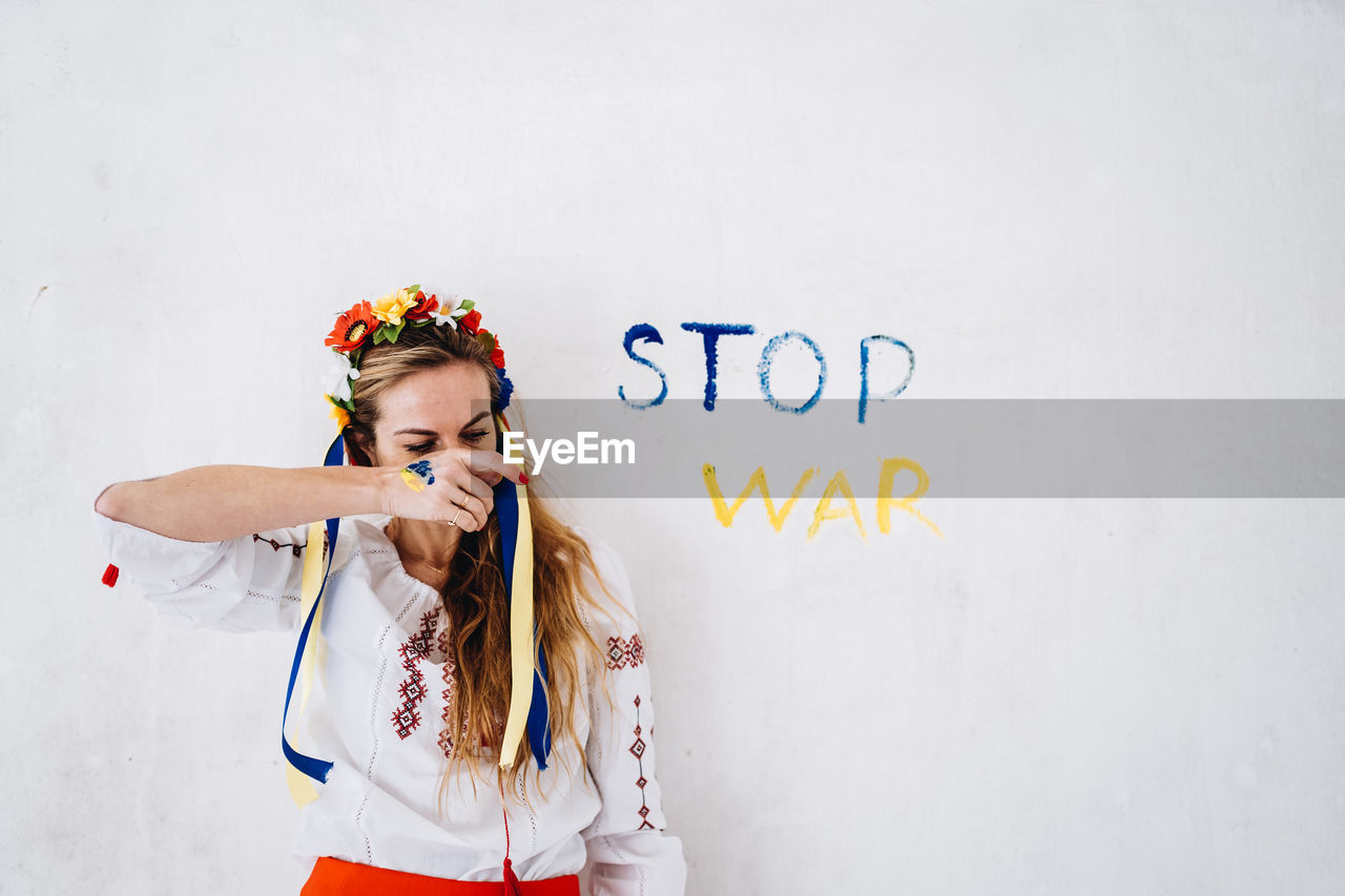 Woman wearing tiara against wall