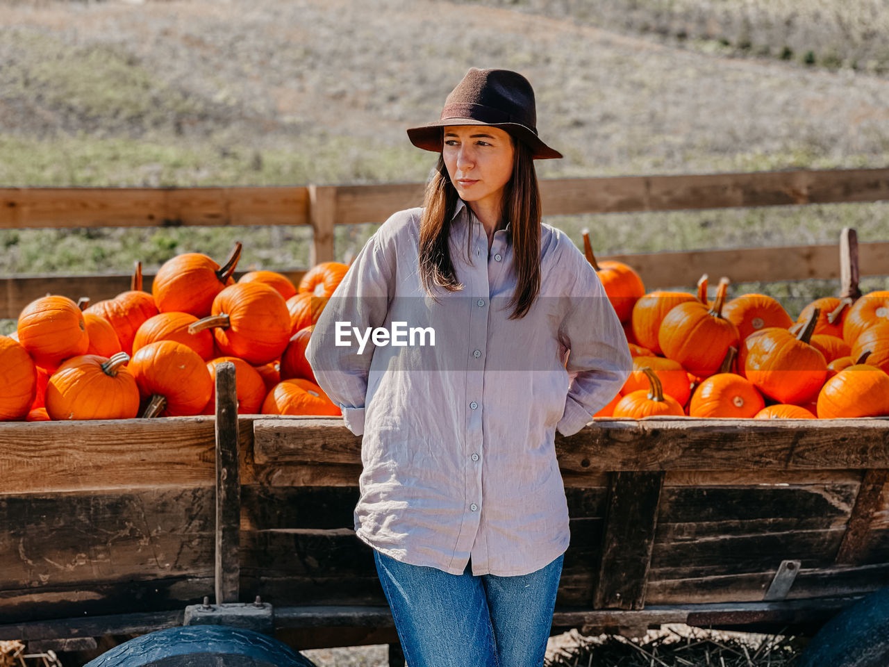 FULL LENGTH OF YOUNG WOMAN STANDING ON ORANGE FRUIT