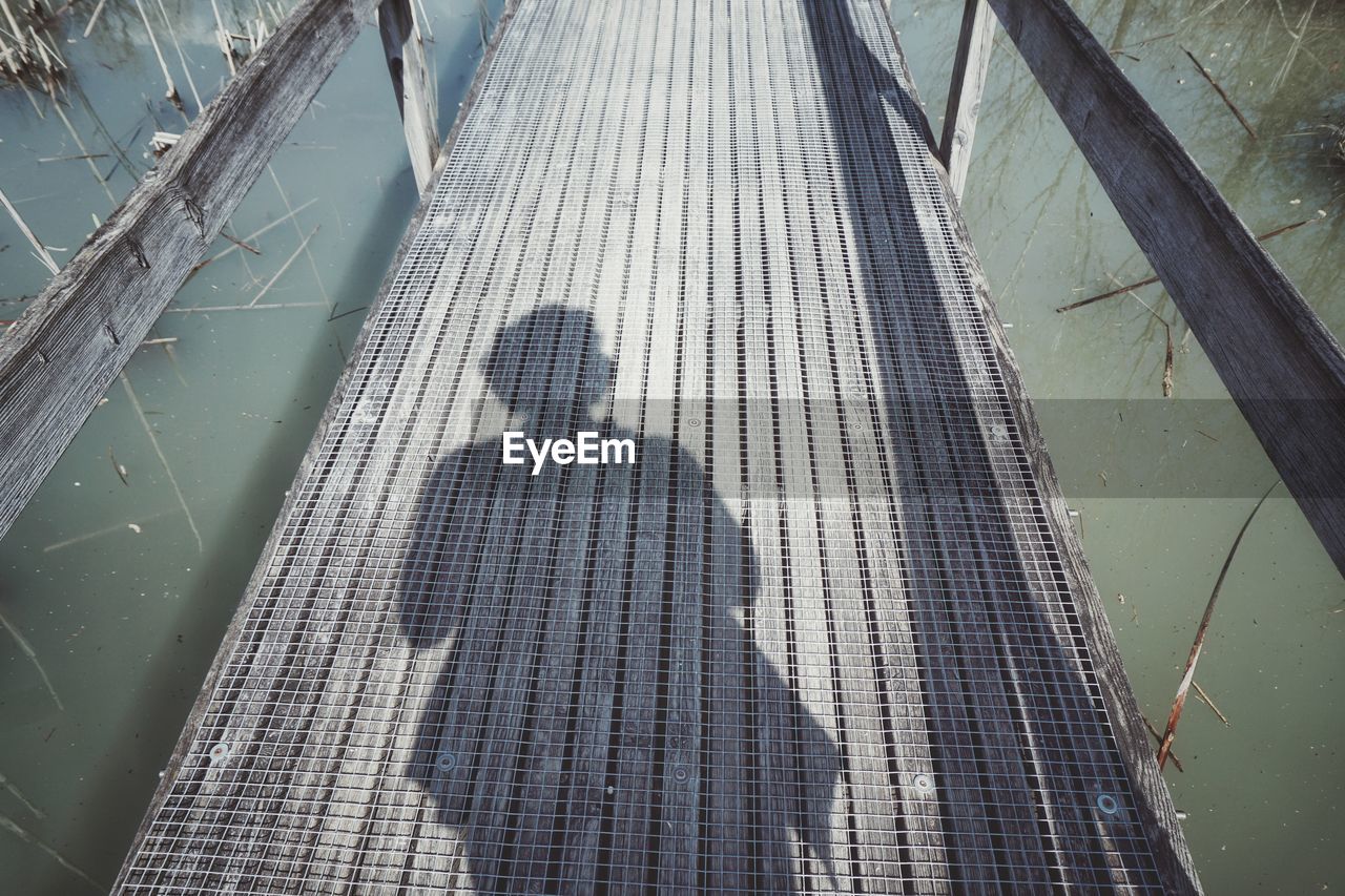 HIGH ANGLE VIEW OF SHADOW ON RAILING