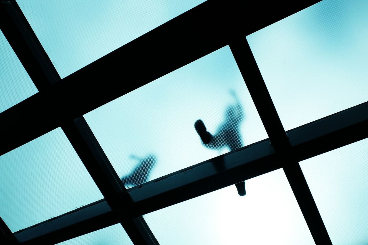 Low angle view of people walking on glass floor