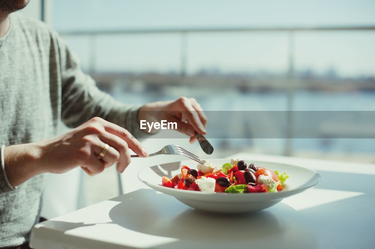 Midsection of man having food on table