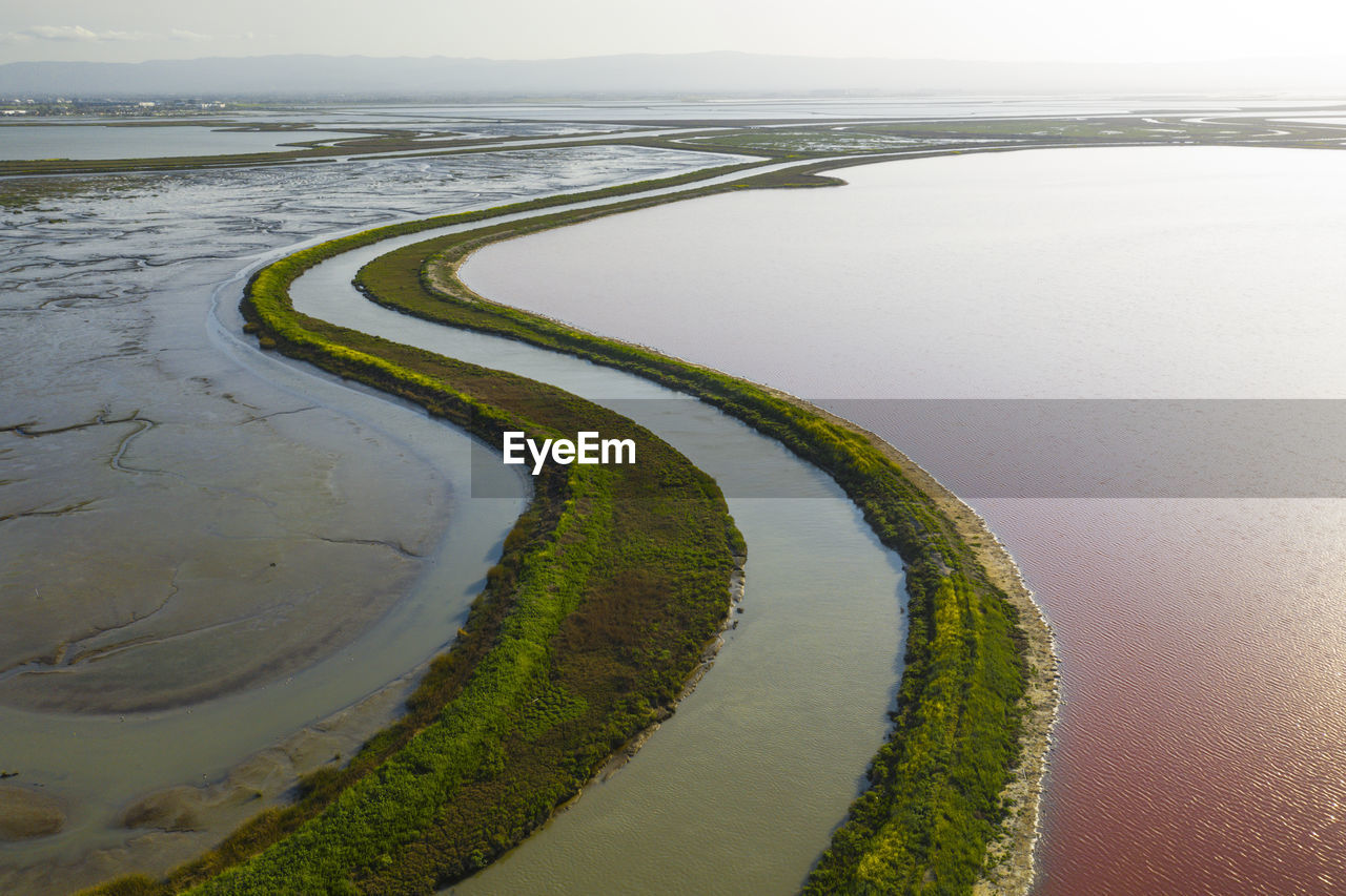 Multi colored water in ponds and stream in salt marsh in sf bay aerial