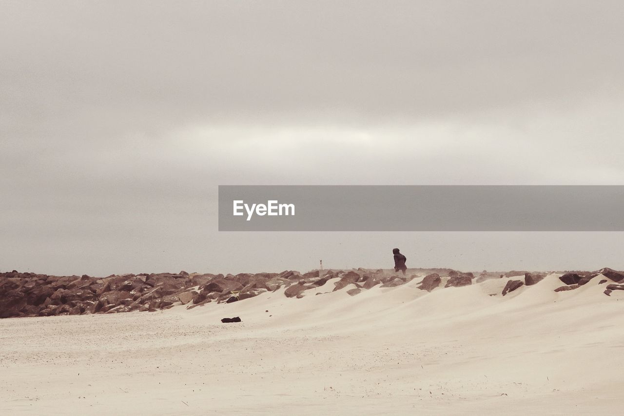 Person on beach against sky