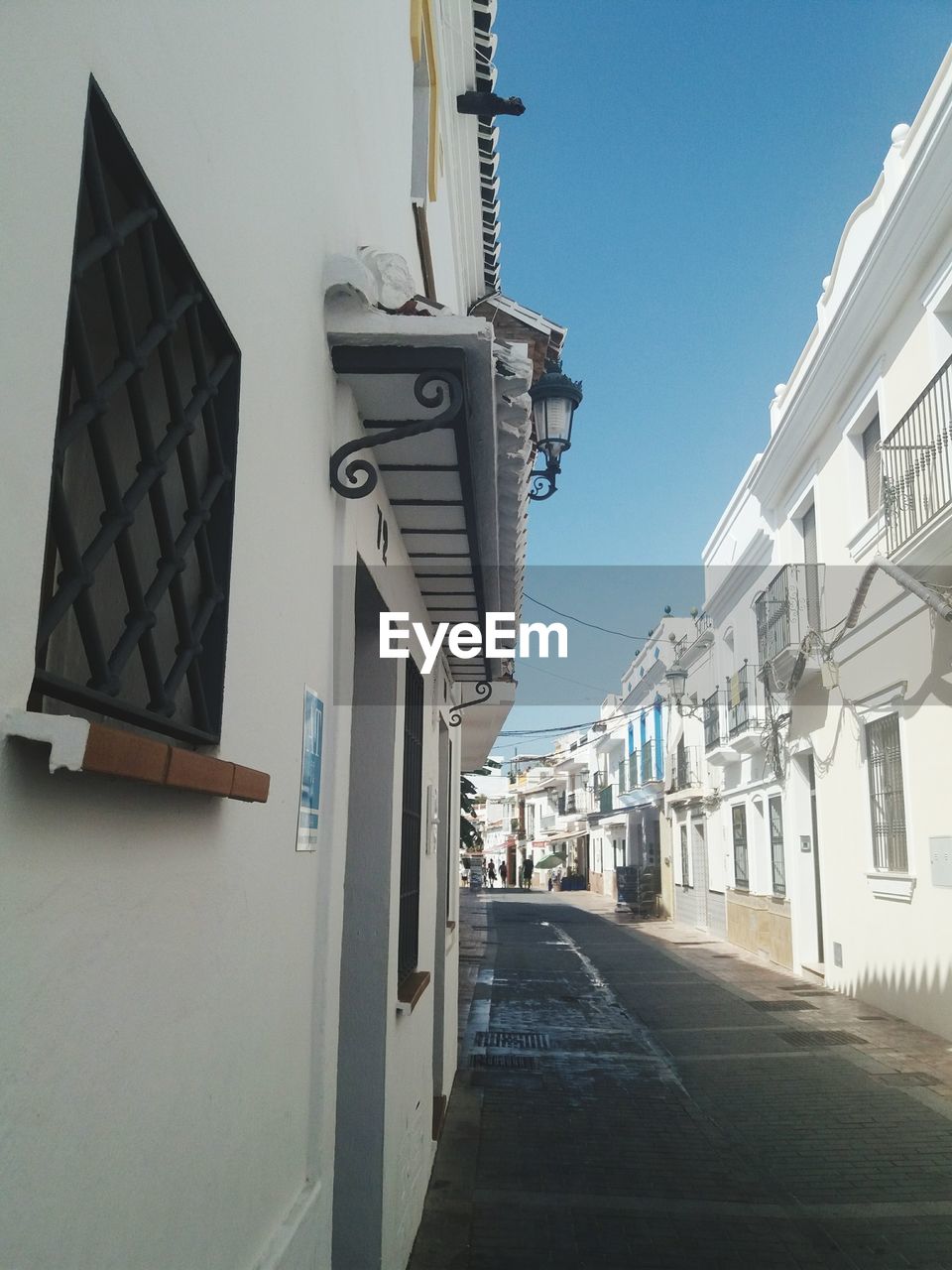 ROAD AMIDST BUILDINGS AGAINST SKY