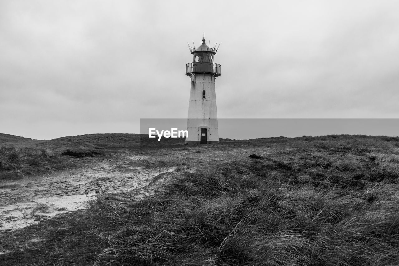 Lighthouse by sea against sky