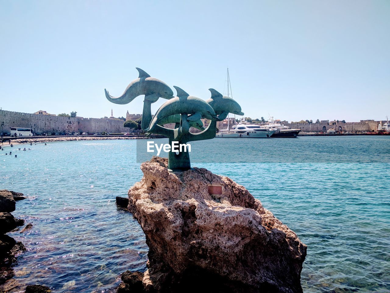 SCULPTURE ON ROCK AGAINST SEA