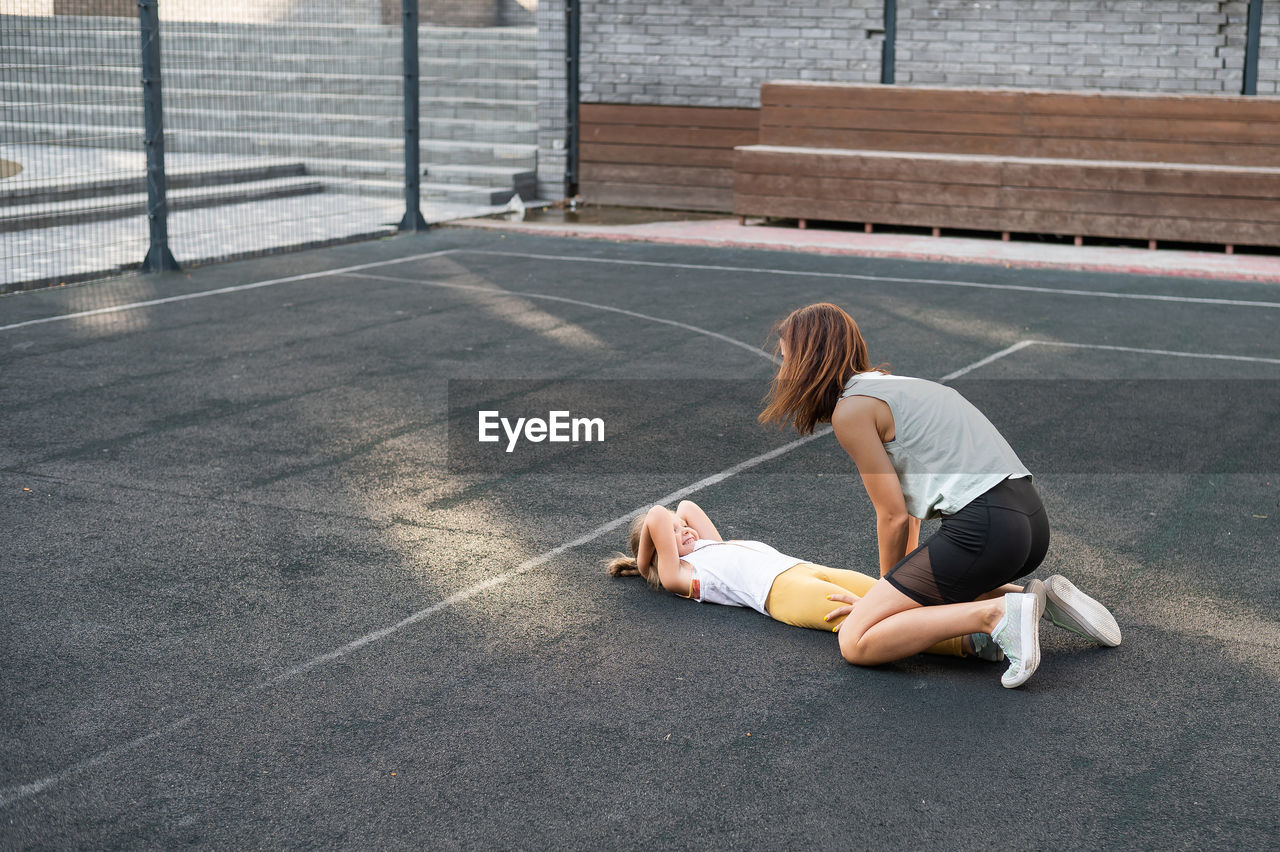 Mother helping daughter exercising