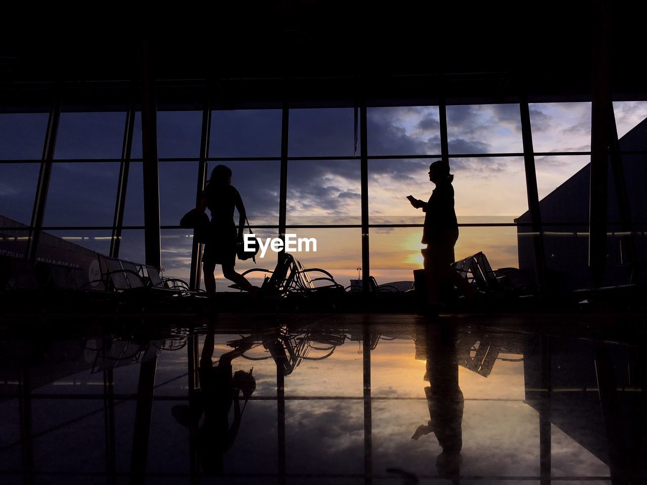 Silhouette women at airport waiting room