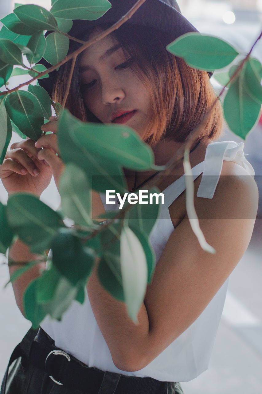 PORTRAIT OF A YOUNG WOMAN WITH PLANTS