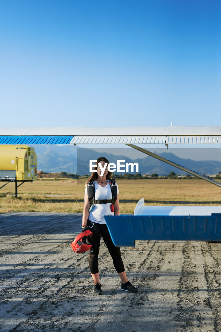Young female skydiver with backpack in an airfield