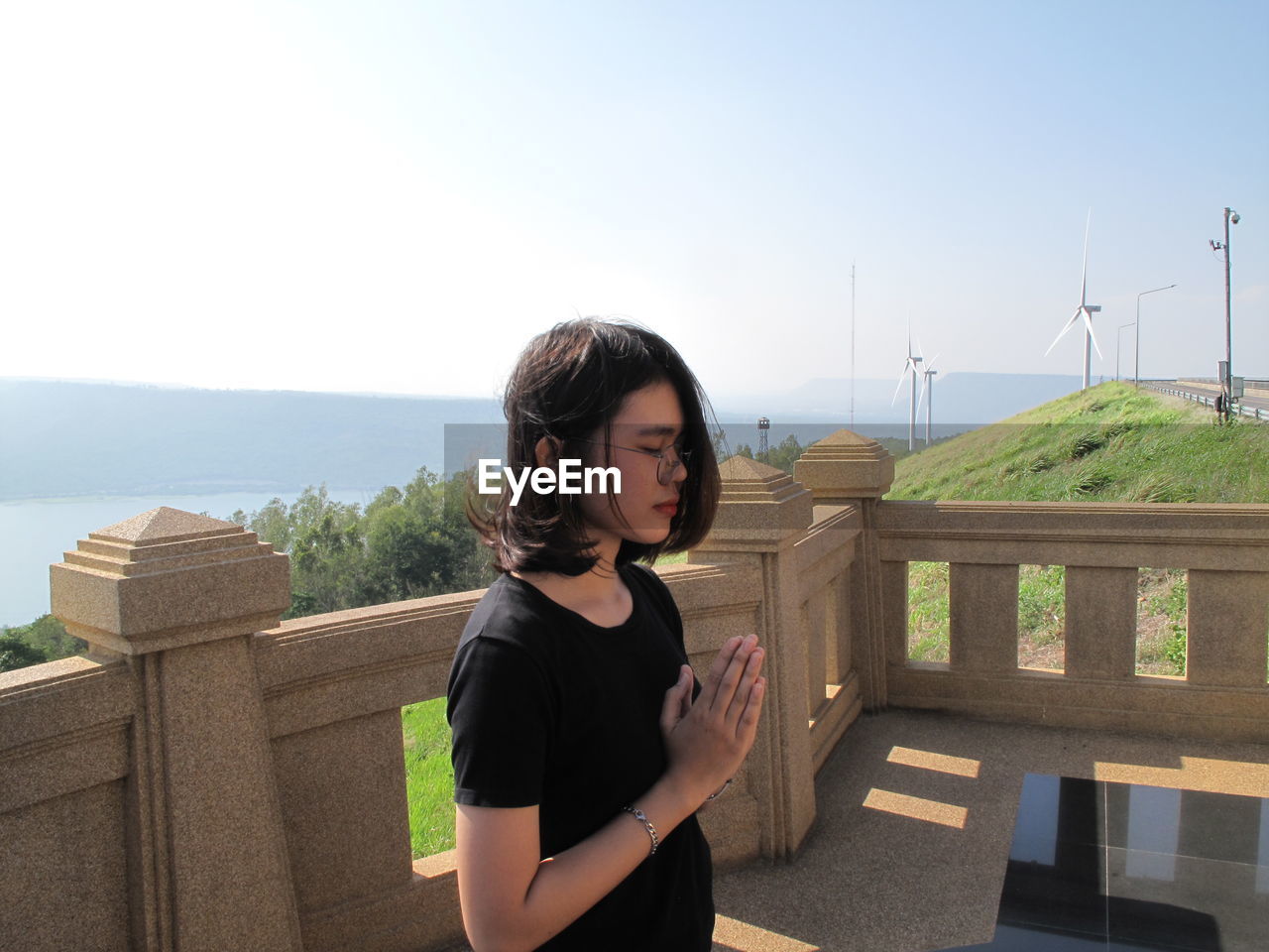 Woman meditating against clear sky