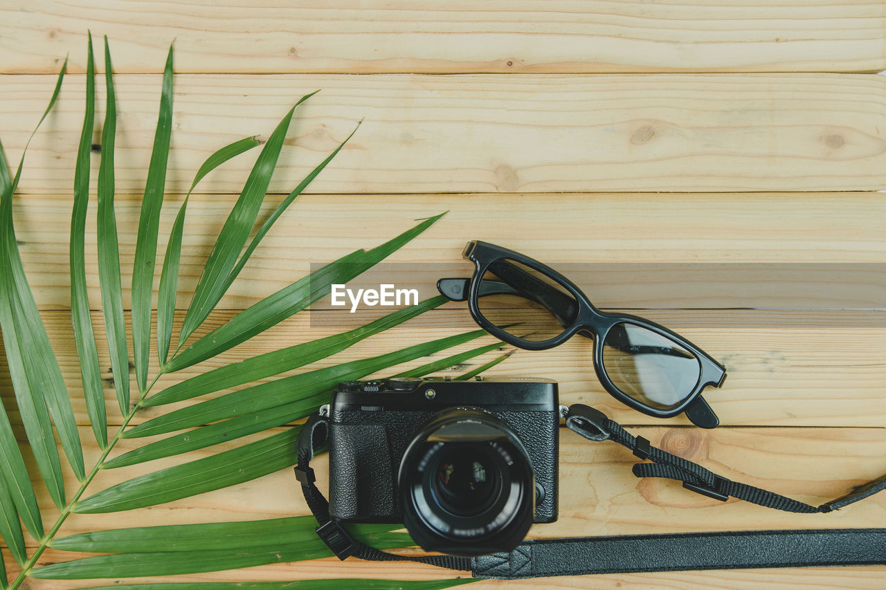 Directly above shot of camera and sunglasses on table