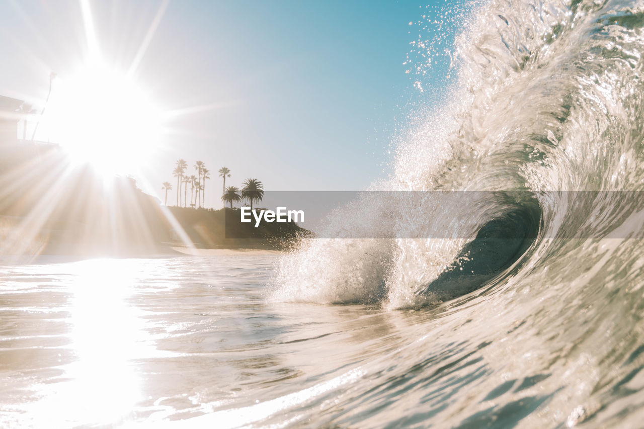 Waves splashing in sea during sunny day