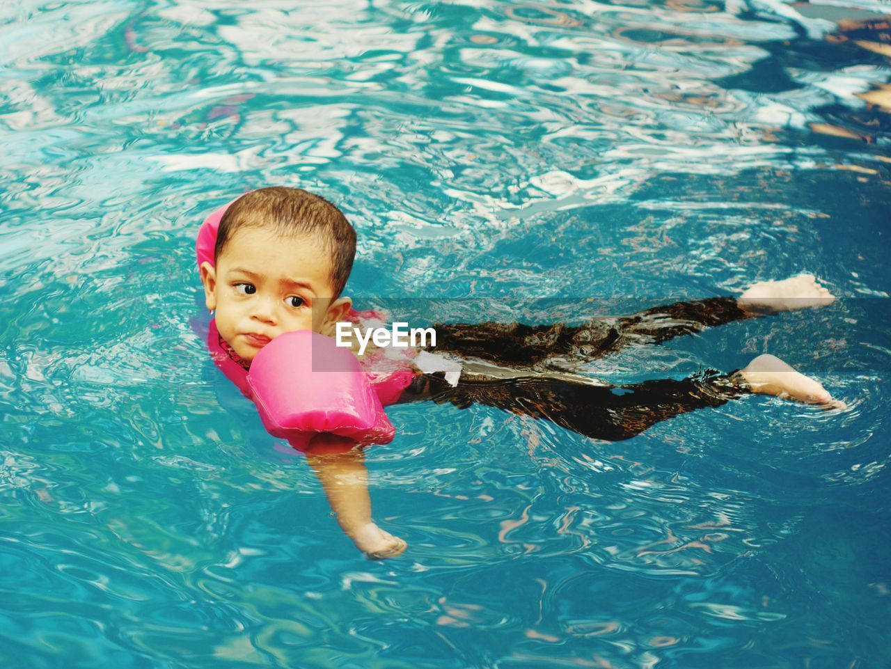 Boy looking away while swimming in pool