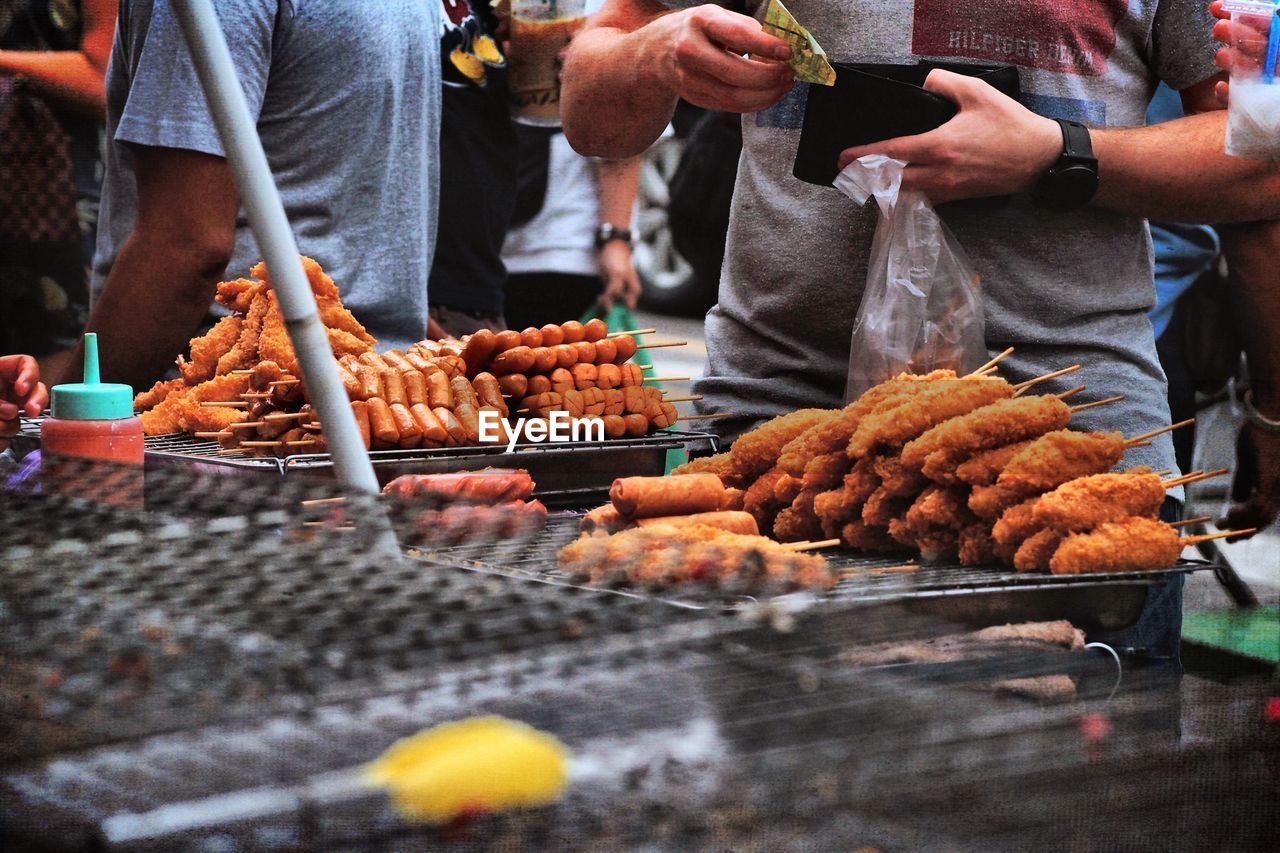 Midsection of man buying food at market