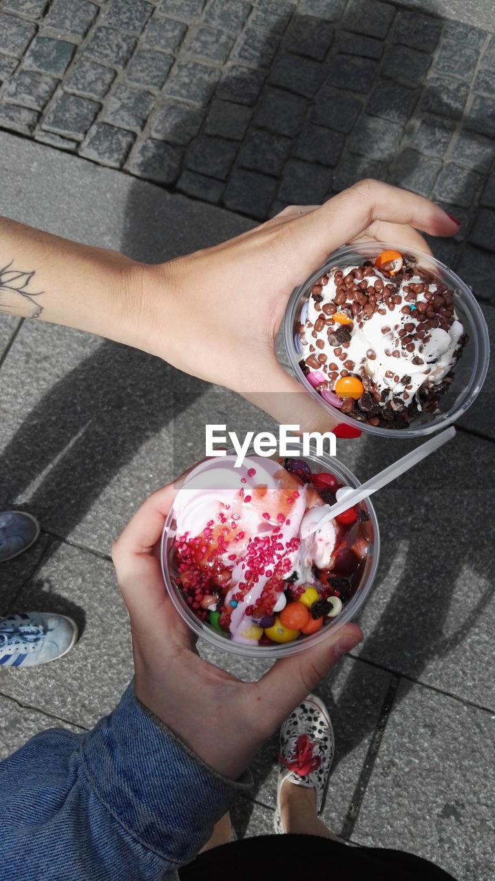 HIGH ANGLE VIEW OF WOMAN HOLDING ICE CREAM