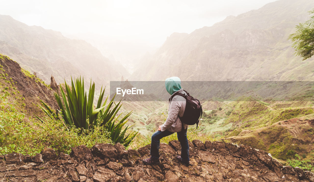 Man standing on land against mountains